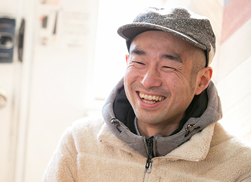 帽子をかぶり笑顔の天野琢也さんの写真