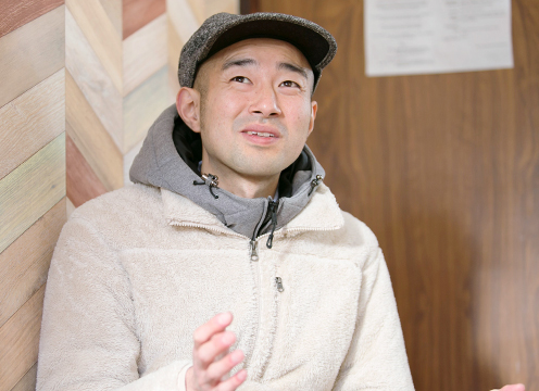 視線を上に向け日光移住インタビューを受けている天野琢也さんの写真