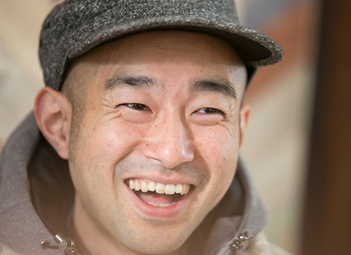 帽子を被り笑顔の天野琢也さんの顔をアップで写した写真