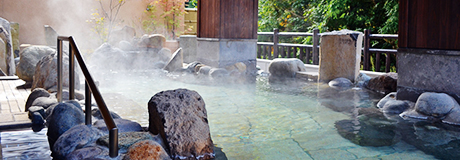 お湯から湯気が立ち上がっている温泉の写真