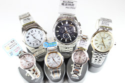 時計のベルト部分がシルバーで文字盤が白、黒、クリーム色の男性物、白とピンクの文字盤の女性物の時計が各3ケずつ並んでいる写真