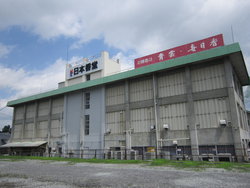 屋根の周りだけが緑色になっている四角の形をした株式会社日本香堂 日光工場の外観を写した写真