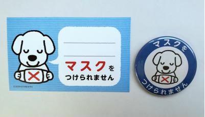 「マスクをつけられません」と書かれた記入欄のあるカードとバッジが並んで置かれている写真