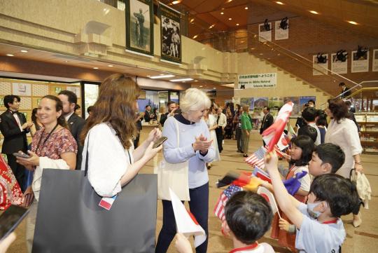 視察旅行に訪れたG7関係者の方々を各国旗を持って歓迎している子ども達の写真