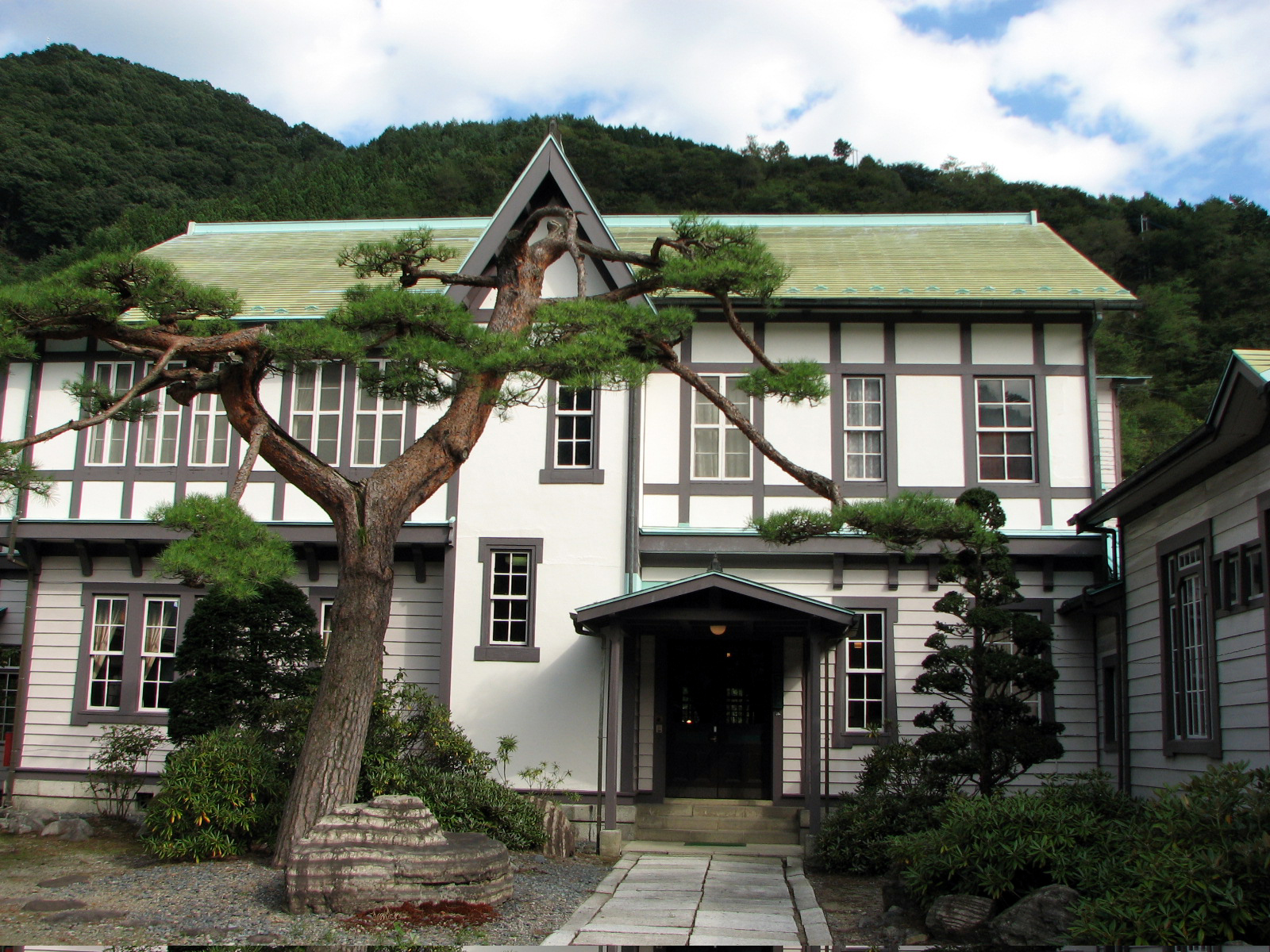 屋根がモスグリーンで外壁が白い古河掛水倶楽部の建物を正面から写した写真