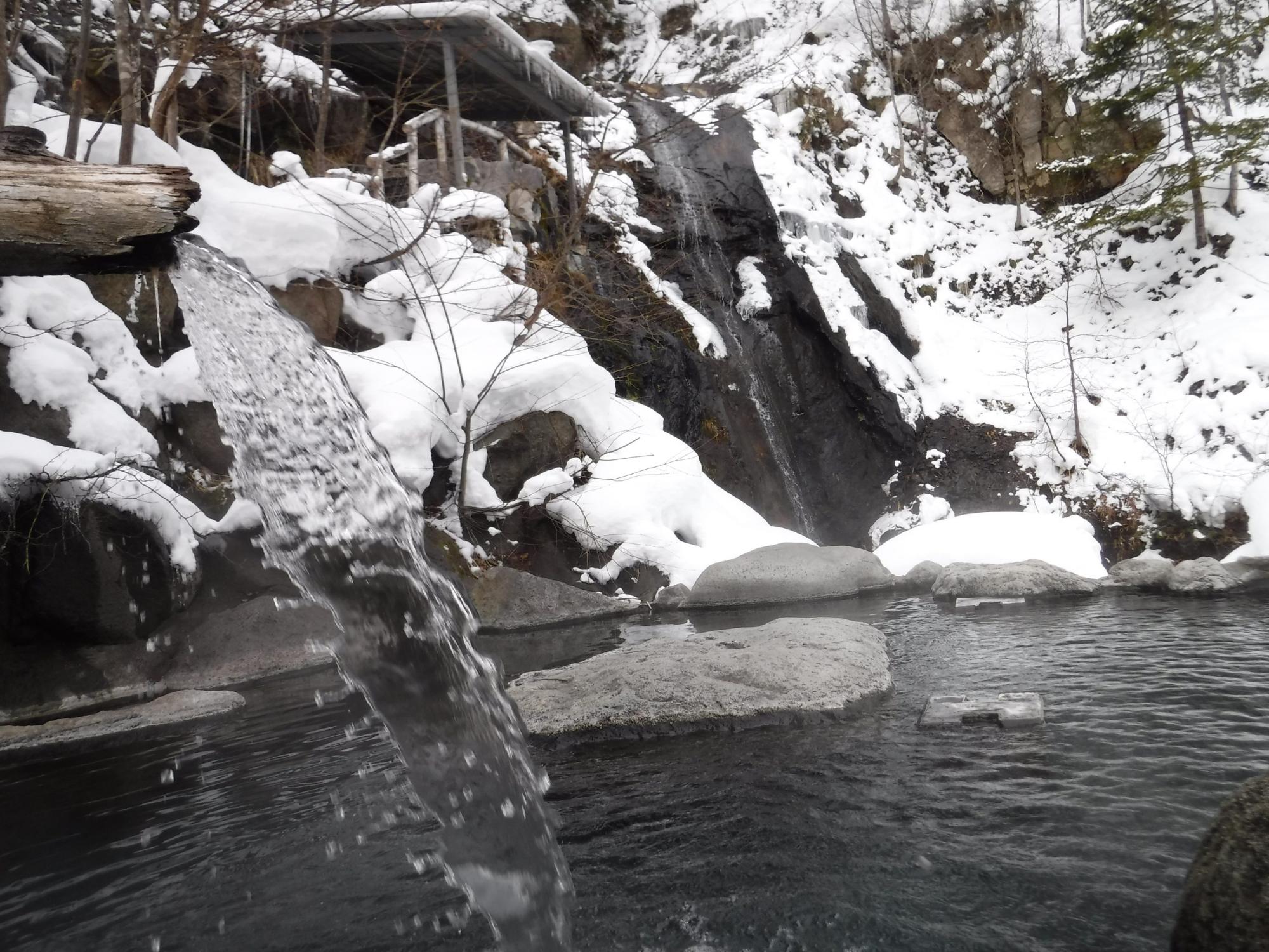 山に雪が積もり、滝まで凍っている様子を写した写真