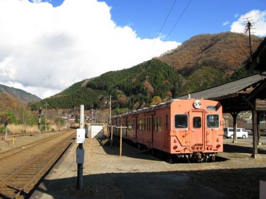 足尾駅ホームの右にオレンジ色の電車が停まっている写真
