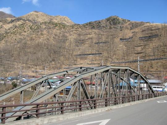 高い山を背景に、古河橋を斜めから撮った写真