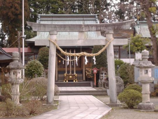 参道の両わきに石燈籠、鳥居にはしめ縄がかかってる神社の写真