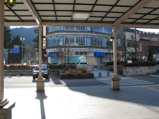 JR日光駅の中から見た駅前道路とビルなどの建物の写真