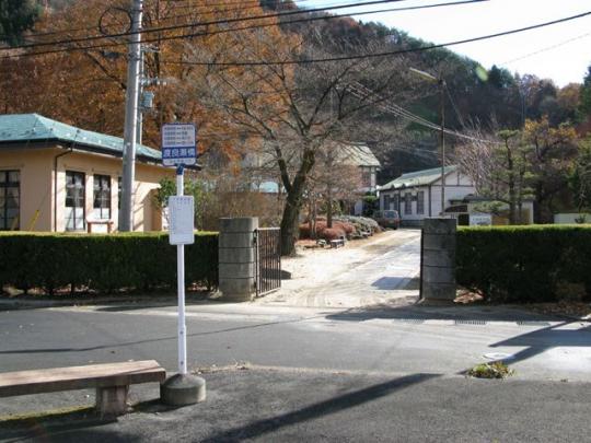古河掛水倶楽部の門の外の道路とバス停の写真