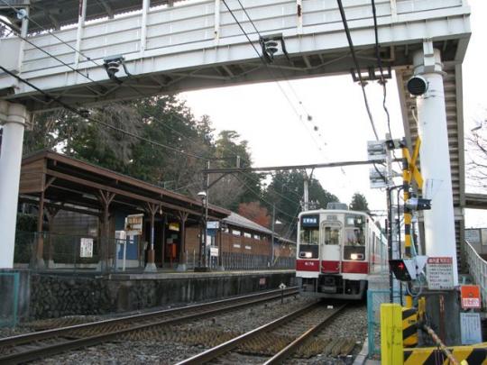 上今市駅に停車している赤いラインの入った電車の写真