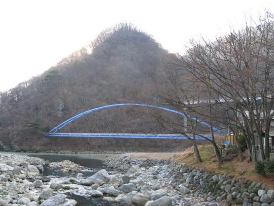 山を背景に青い黄金橋の写真
