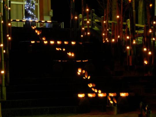 階段とその周りを、蠟燭を灯したたくさんの竹で飾った幻想的な様子の写真