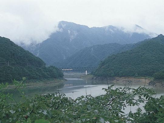 雄大な山を背景に陸橋を渡る会津鬼怒川線の写真