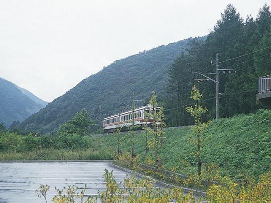 山を背景に緑の中を進む会津鬼怒川線の写真