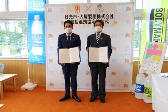 大塚製薬の方と市長が協定書を持っている包括連携協定締結式の写真