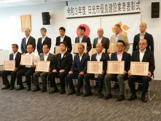 10名の方が賞状を持ち、前列から8名、7名と並んだ15名の優良建設業者表彰式の記念写真
