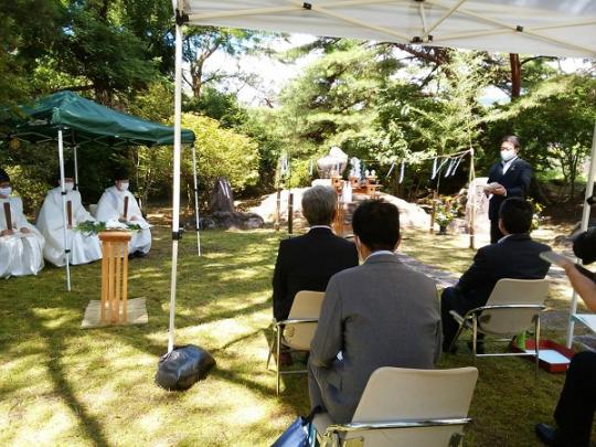左側に3名の神主様、手前に関係者たちが座り、砂防祭で市長があいさつを行っている様子の写真