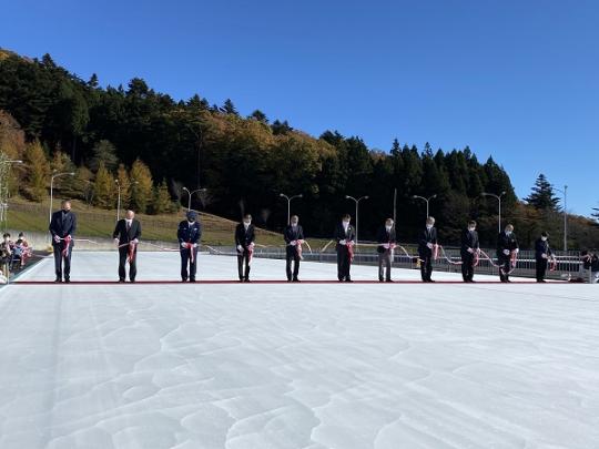 スケートセンターの氷の上で市長と10名の関係者の方々が1列に並びテープカットをしているスケートセンターオープン式の様子の写真