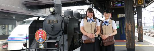 SLの横に立っている、笑顔の中島美樹さん・井池忍さんの写真