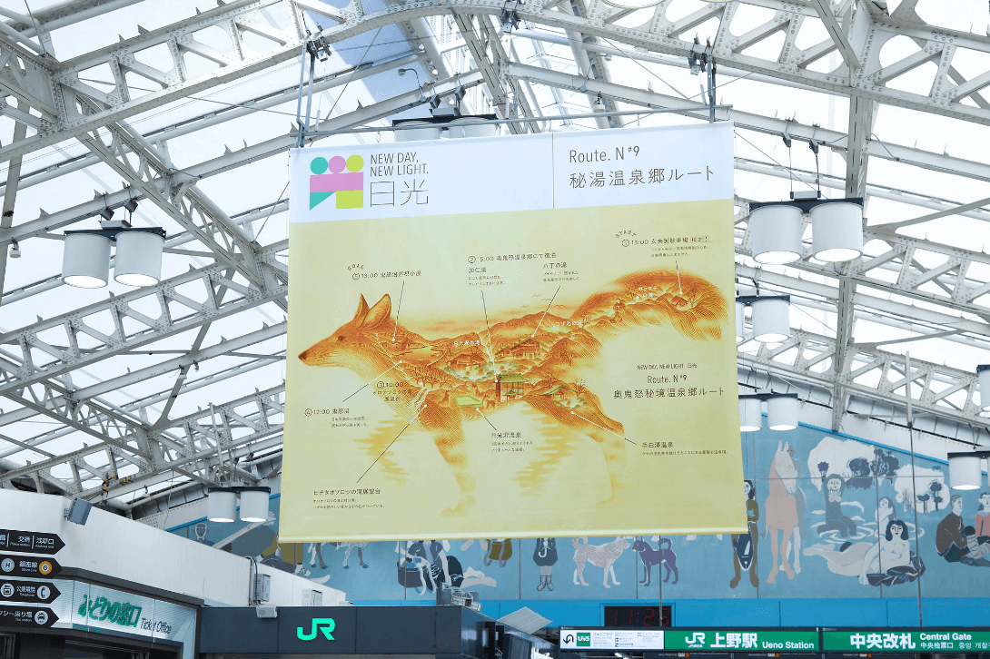 駅構内の上部に、きつねを横から見た姿に奥鬼怒秘境温泉郷の場所が描かれている大きなポスターが吊り下げられている写真