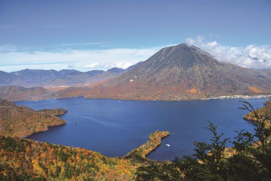 中禅寺湖の奥に山が見えている秋の風景写真