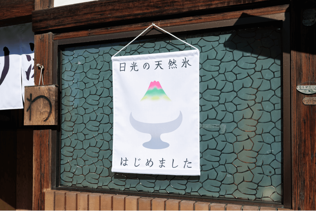 「日光の天然氷はじめました」との文字とかき氷のイラストが描かれた暖簾の写真