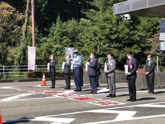 左胸にリボンを付けスーツを着た男性6人が並んでいる鬼怒川有料道路引継ぎ式の写真