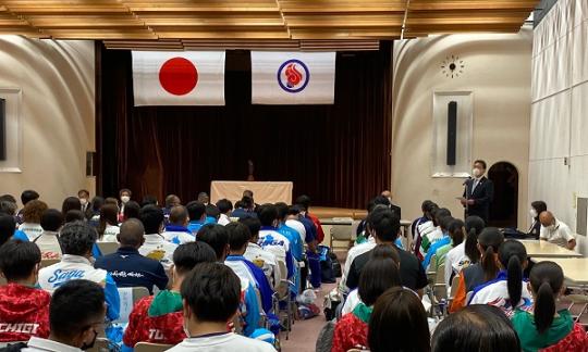 前方で市長が話をするのを沢山の選手が聞いている国体ホッケー競技代表者会議の様子の写真
