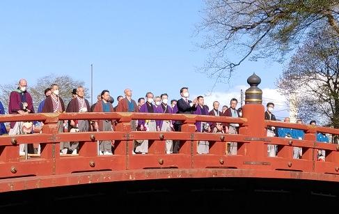 朱色の橋の上に市長と袴姿の関係者が並んでいる宵まつりの様子の写真