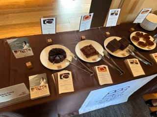 茶色いクロスが敷かれた机の上に展示されたお菓子やパンフレットの写真