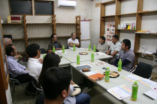 お茶を飲みながら机を囲む十人の参加者の写真