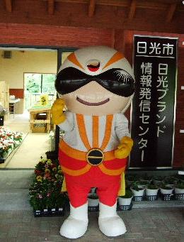 日光ブランド情報発信センターの入り口でポーズをしている日光市ゆるキャラ日光仮面の写真