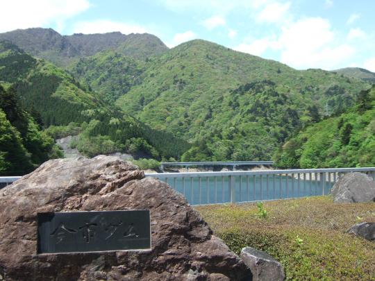 山々の下にある今市ダムと山市ダムと書かれた石碑の写真