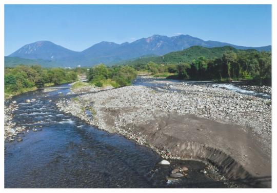 日光連山を背景に流れる大谷川の写真