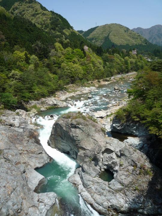 鬼怒岩橋から見た山々と険しい岩の間を流れる鬼怒川の写真