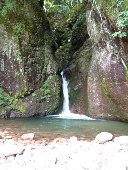 岩の間から流れ落ちるコザ池の滝の写真