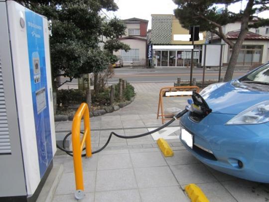 青い車が、急速充電器で充電している写真
