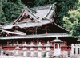 横一列に並んでいる複数の石灯籠と屋根付きの塀の奥に見えている二荒山神社本殿の写真