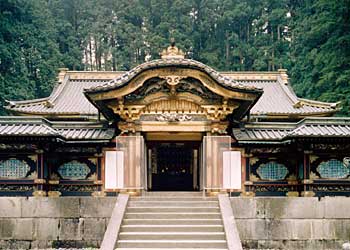 石で出来た階段の上に入口があり、入口の左右に瑞垣が延びており、門の上部には金色で装飾がされている大猷院霊廟唐門を正面から写した写真