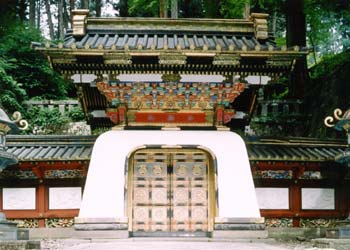 切妻造、門上部に赤や青、金色で装飾がされ、門の腰壁が白色に塗られている大猷院霊廟皇嘉門の写真