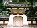 切妻造、門上部に赤や青、金色で装飾がされ、門の腰壁が白色に塗られている大猷院霊廟皇嘉門の写真