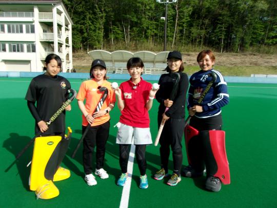 ホッケースティックを持った5人の女の子が並んで記念撮影をしている写真