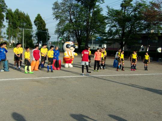 マスコットキャラクターと一緒に大勢の観客者がホッケーの試合を観戦している写真