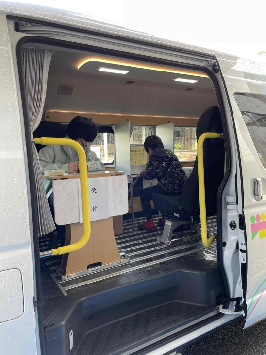 開いたスライドドアの両側に黄色い手すりが付いているマルチタスク車両の写真