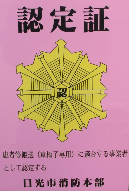 ピンク色の下地に認定証と書かれた患者等搬送用自動車認定マークの写真