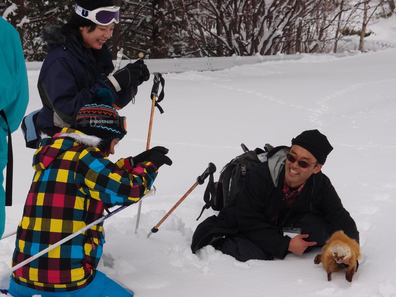 雪山で子どもと笑いながらガイドをする安倍さん
