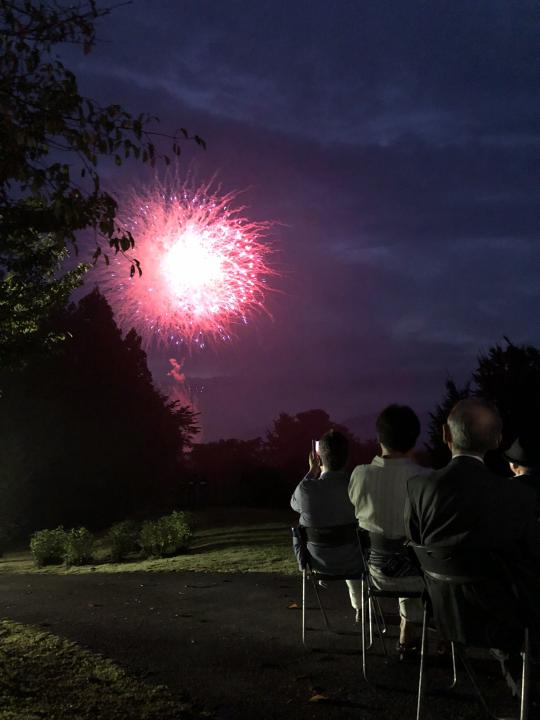 日光花火大会で夜空に上がる花火を見上げる観客のようす