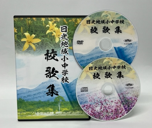 「日光地域小中学校校歌集」と書かれ、花や山々の風景が印刷された本体ケースとCD・DVDの写真